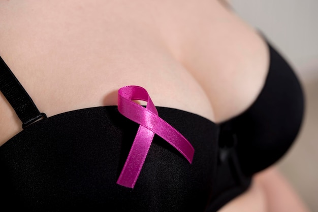 Cuidados de saúde, medicina e conceito de conscientização do câncer de mama. Jovem mulher nua com símbolo de fita rosa
