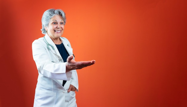 Cuidados de saúde - Médico brasileiro maduro ou mulher veterinária com estetoscópio isolado em laranja