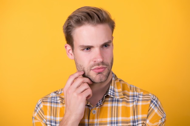 Cuidados faciais Homem bonito com rosto não barbeado fundo amarelo Pele jovem Cuidados com a barba Cosméticos para a pele Produtos cosméticos Rotina de cuidados com a pele Esfregar e esfregar Linha de barbear Creme pós-barba