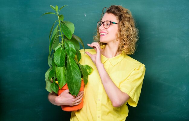 Cuidando las flores niña estudiante feliz con planta en pizarra maestra mujer con gafas en la lección de biología árbol del conocimiento educación ambiental escuela naturaleza estudio