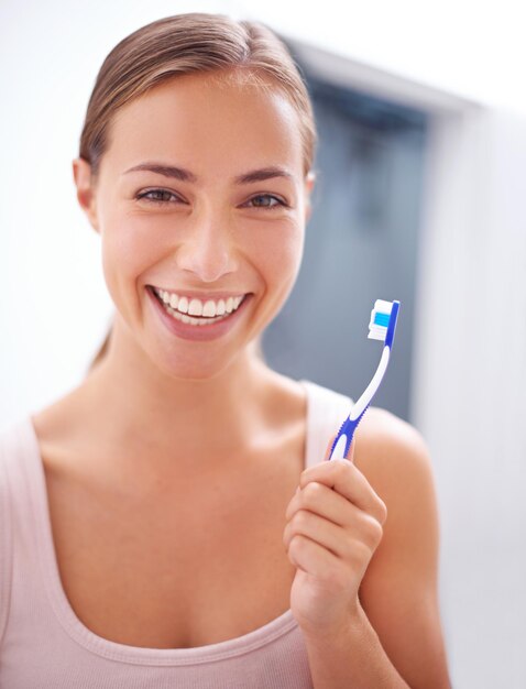 Cuidando su sonrisa Una mujer joven cepillándose los dientes