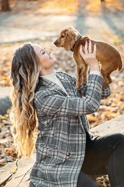 Cuidando a tu mascota en otoño lindo cachorro de cocker spaniel inglés caminando con su dueña en otoño