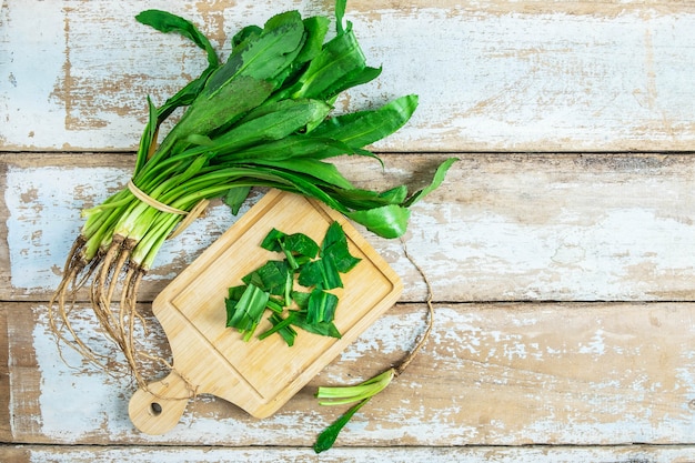 Culantro de hierbas sobre una tabla de cortar de madera.