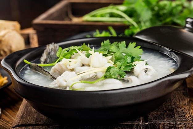 Culinária chinesa Congee com rodelas de peixe na caçarola