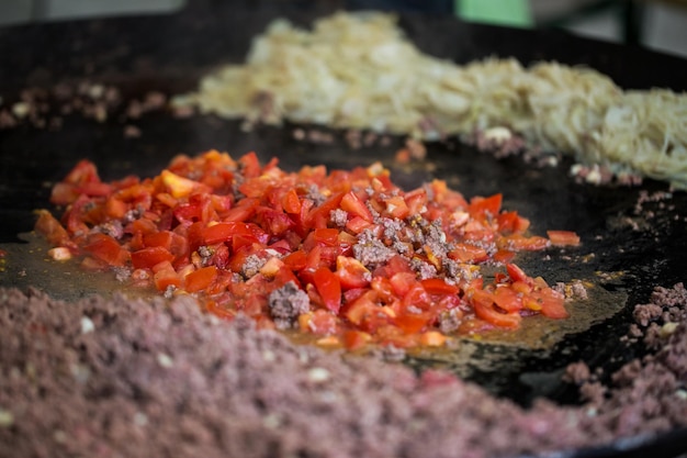 culinária, cozinha asiática, venda e conceito de comida - legumes fritando na panela wok grande no mercado de rua