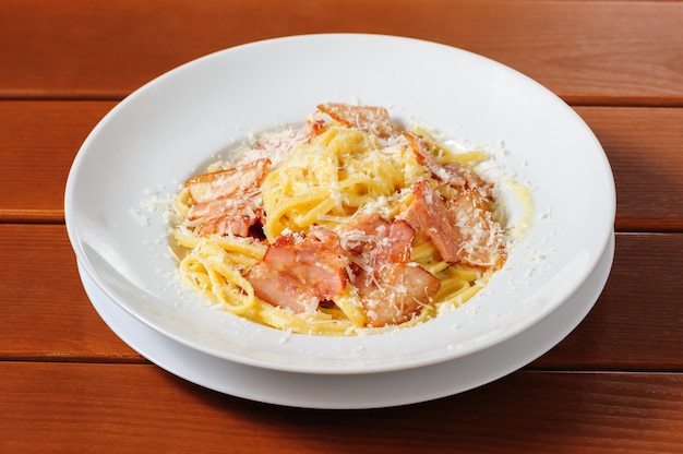 Culinária italiana de tagliatelli carbanara na placa fundo de mesa de cozinha rústica