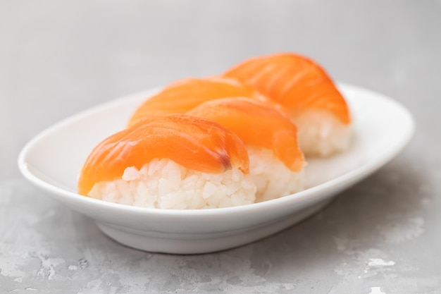 Culinária japonesa Sushi de salmão nigiri num prato branco