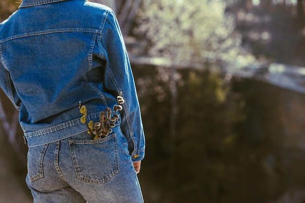 Culo de mujer en jeans floreciendo flores en vista de bolsillo desde atrás