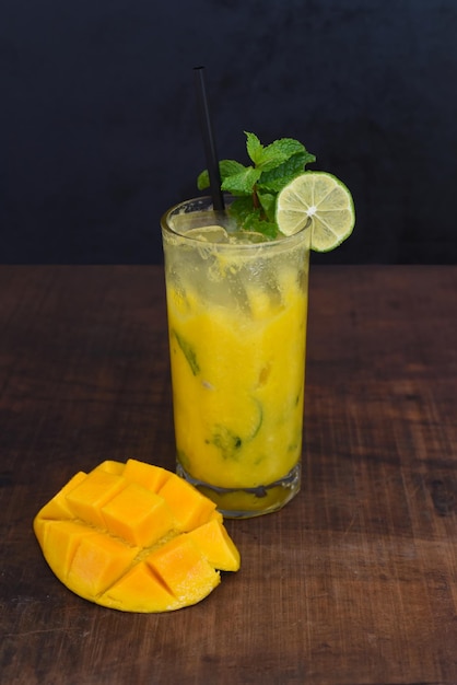 Óculos altos com mojito de manga na mesa de madeira e fundo preto