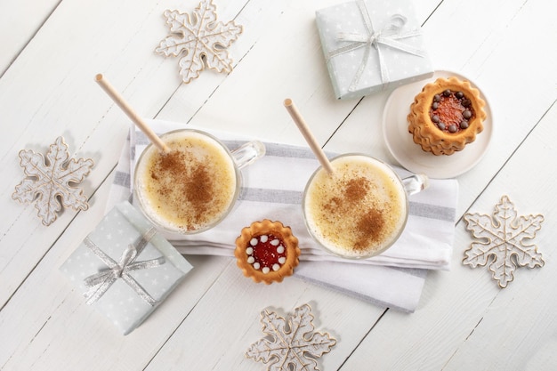 Óculos com caixas de presente de biscoitos de gemada de Natal flocos de neve na mesa de madeira branca Vista superior