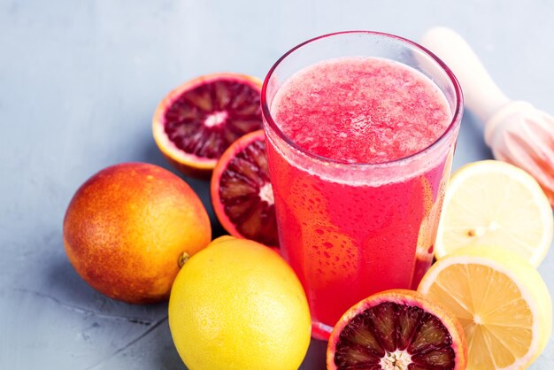 Óculos com laranja de sangue e limonada de limão Lugar para texto Fundo azul