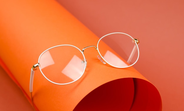 Óculos com lentes redondas em armação branca sobre fundo laranja Óculos para visão Óculos elegantes Óculos como acessório