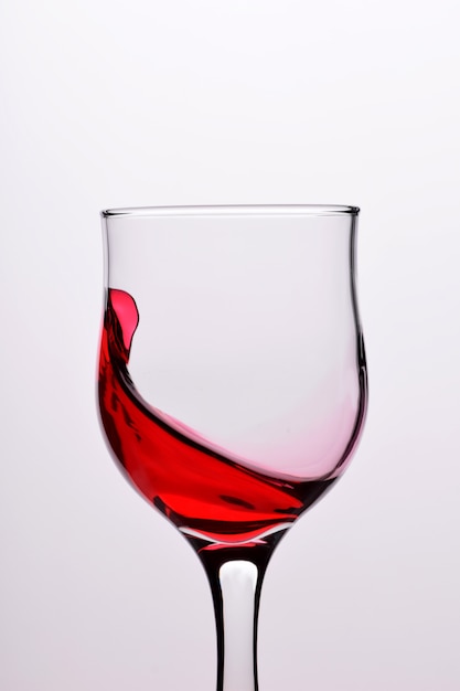 Óculos com ondas plash de vinho tinto em um fundo branco