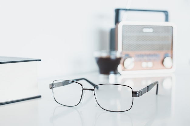 Óculos com rádio, livro e café