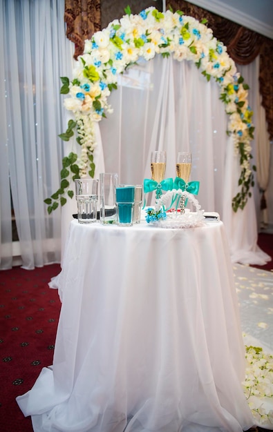 Óculos de casamento em cima da mesa contra o fundo do arco