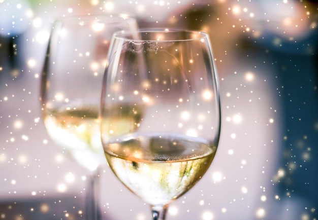 Óculos de férias de inverno de vinho branco e neve brilhante no fundo do romance de Natal