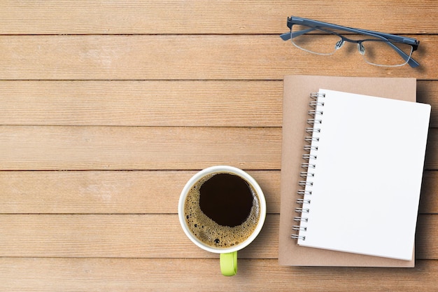 Óculos de notebook e café na mesa de madeira