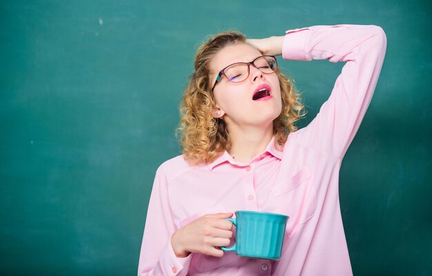 Óculos de professor bebem fundo de quadro-negro de café. Mulher gosta de café antes das aulas. Beba recarregando corpo e mente. De volta à escola. Viciado em café. Carga de energia para o dia inteiro. Dose de cafeína.