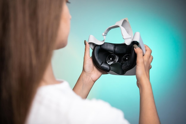 Óculos de realidade virtual à disposição sobre o fundo colorido. Tecnologia do futuro, conceito de RV