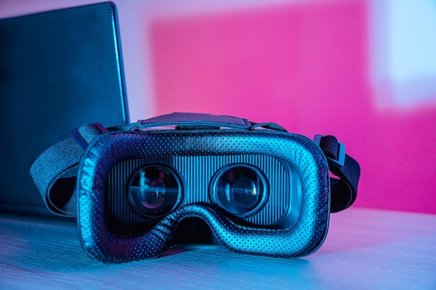 Óculos de realidade virtual e laptop com fundos coloridos