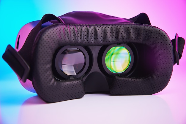 Óculos de realidade virtual na parede colorida. Tecnologia do futuro, conceito de RV