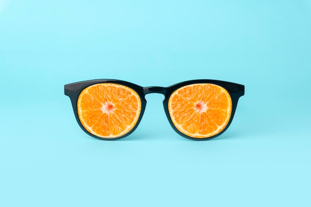Óculos de sol de conceito de férias de verão com laranjas suculentas em fundo branco mínimo de luz brilhante