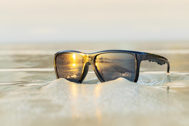 Óculos de sol na areia linda praia de verão