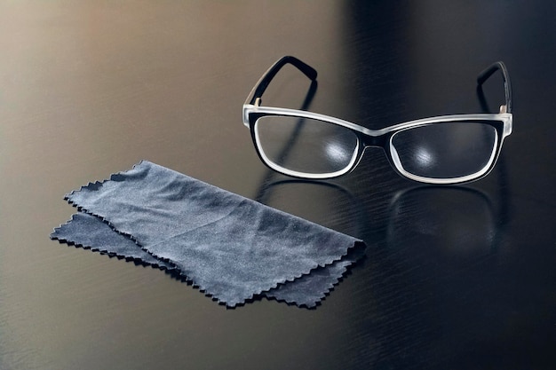 Óculos e um guardanapo preto em uma mesa de madeira