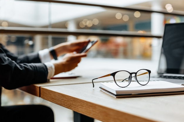 Óculos no local de trabalho no escritório perto do laptop e do bloco de notas. Horário comercial