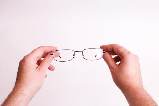 Óculos para visão nas mãos em fundo cinza