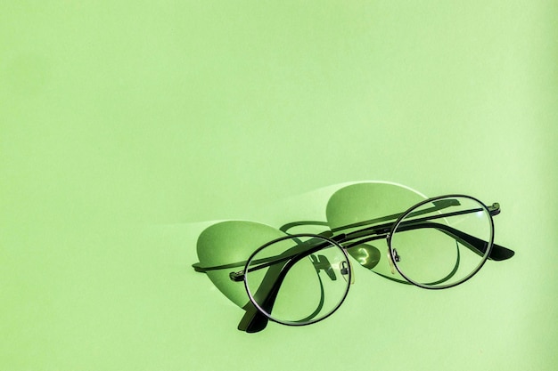 Óculos pretos de negócios em óculos de escritório com fundo verde lendo em conceito para banner promocional