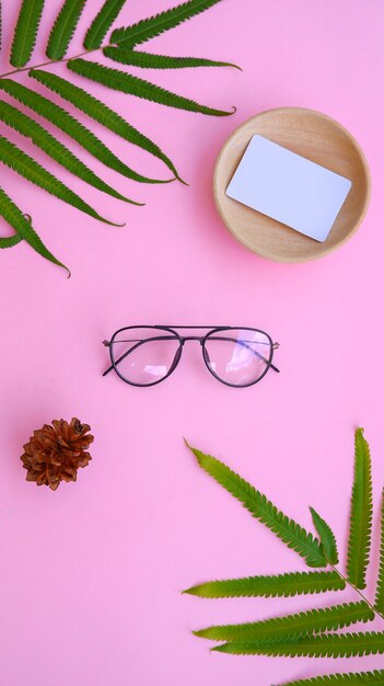 Óculos redondos na foto em estilo minimalista de verão em um fundo de cor rosa pastel.