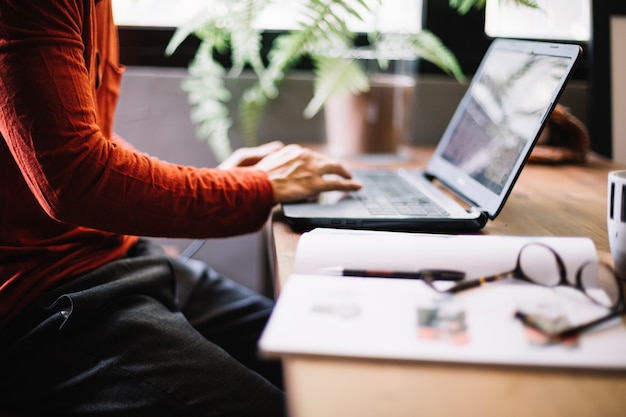 Cultivar hombre trabajando con la computadora portátil