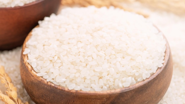 Cultivo de arroz comestible molido pulido blanco crudo sobre fondo blanco en tazón marrón concepto de diseño de agricultura orgánica Alimentos básicos de Asia cerrar