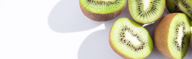 Cultivo panorámico de mitades de kiwi fresco y maduro en blanco