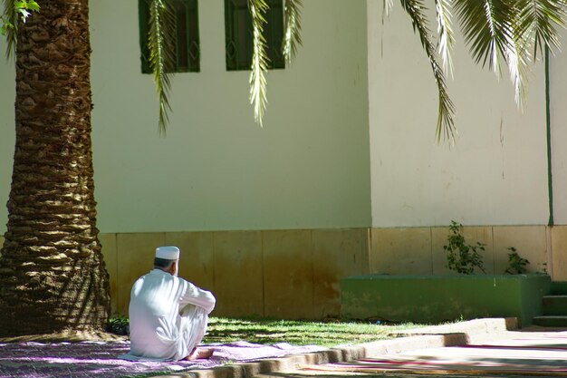 Foto cultura muçulmana um homem ao lado de uma mesquita