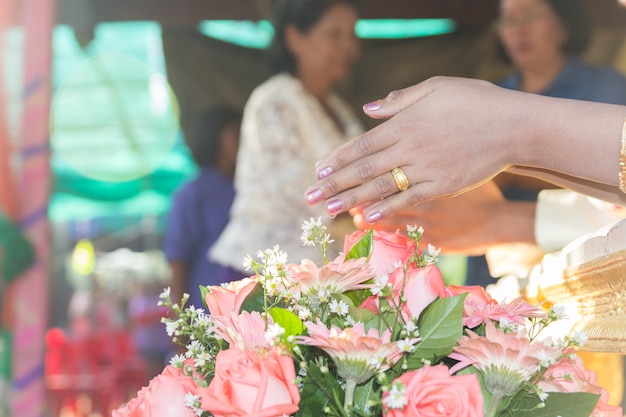 Cultura tailandesa, a mão de uma noiva que recebe água benta na cerimônia de casamento