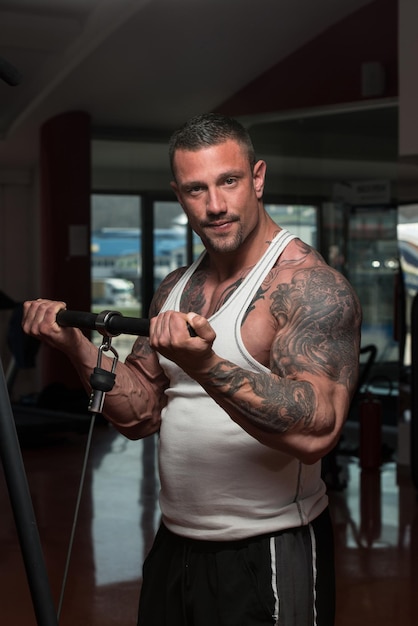 Culturista adulto haciendo ejercicio de peso pesado para bíceps