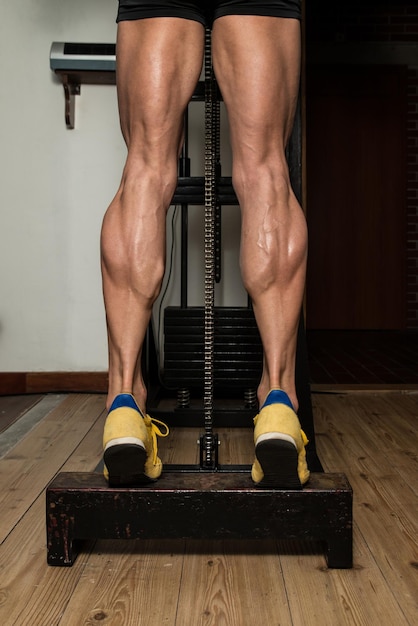 Foto culturista haciendo ejercicio de peso pesado para piernas pantorrillas