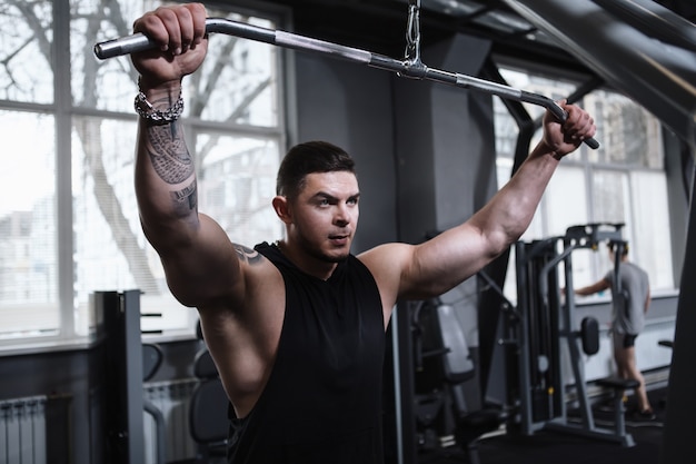 Culturista muscular trabajando en el gimnasio