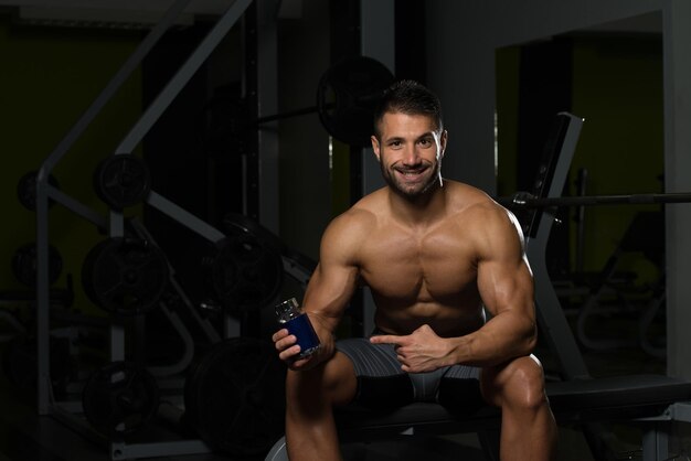 Culturista musculoso guapo con pastillas y droga para copiar espacio