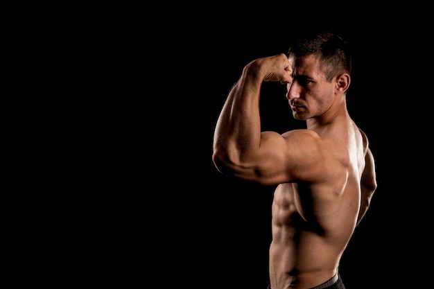 Culturista posando, poder masculino chico deportivo, fitness hombre musculoso, espacio de copia de concepto de spot, fondo oscuro