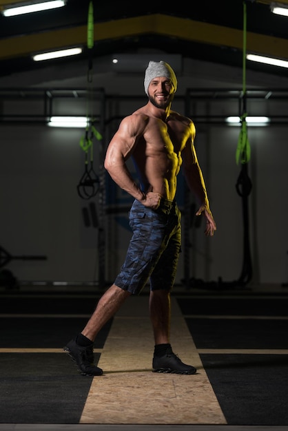 Culturista serio de pie en el gimnasio