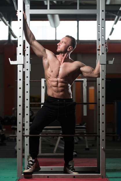 Culturista serio de pie en el gimnasio