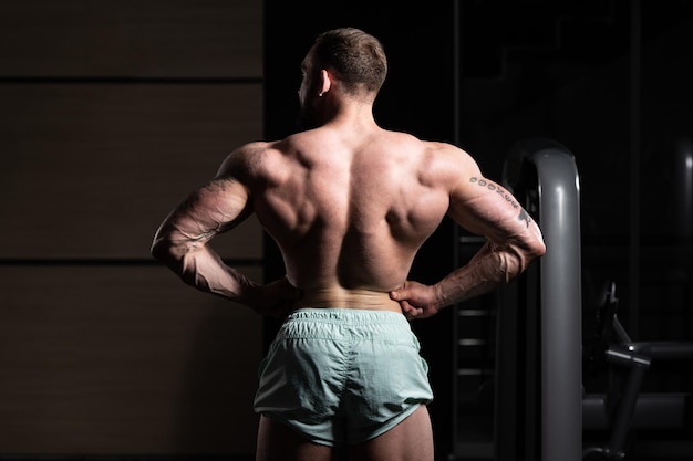 Culturista serio de pie en el gimnasio