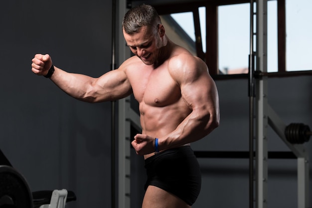 Culturista serio de pie en el gimnasio