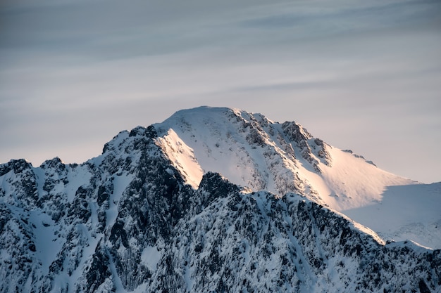 Cumbre de la montaña de nieve con la salida del sol brillando