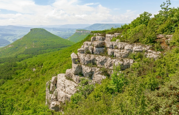 Cume de pedra com plataforma para visualização da paisagem e das montanhas em forma de pirâmide