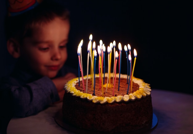 Cumpleaños. Un niño pequeño apaga velas en el horno.