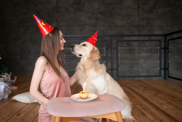 cumpleaños de un perro niña celebra el cumpleaños de un perro y lo abraza en casa